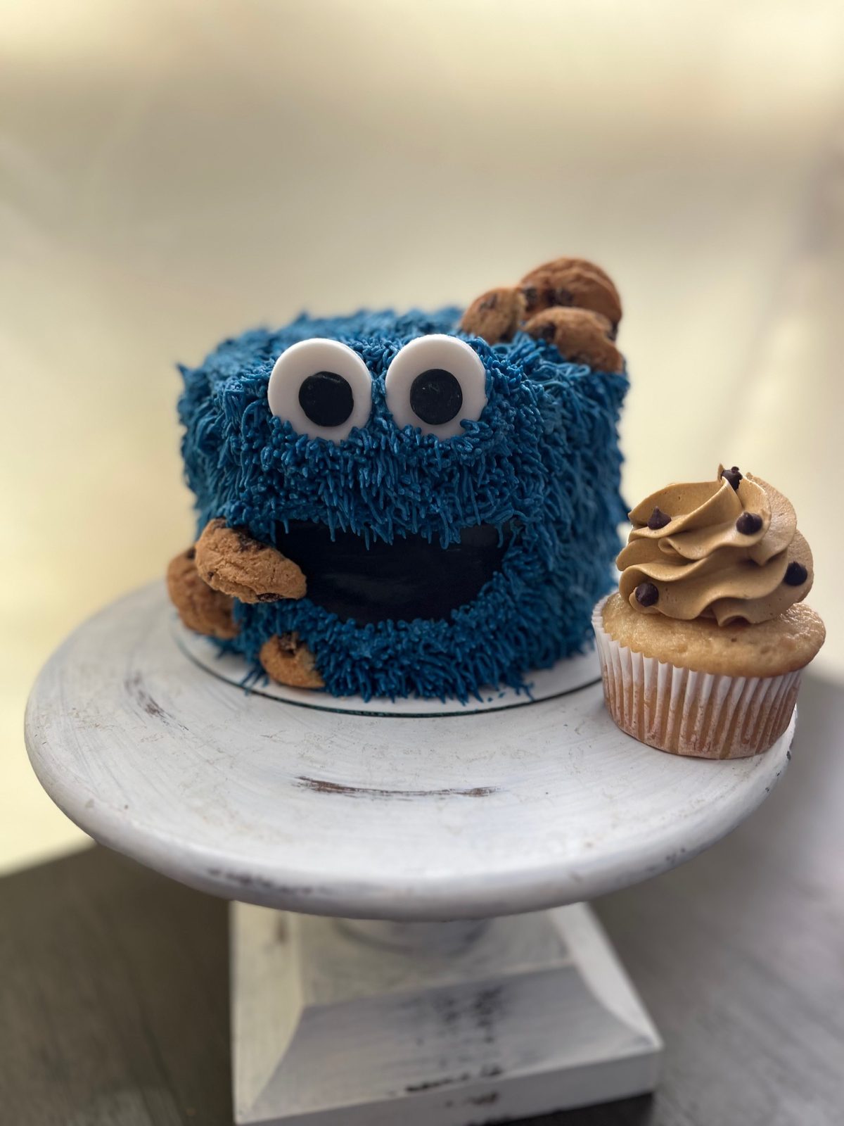 Whimsical blue monster-themed novelty cake with cookie topper made by Bipity Bopity Cakes, Lodi CA bakery